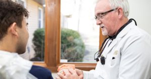 Dr. Kinney explaining the pros of CEREC crowns to a dental patient